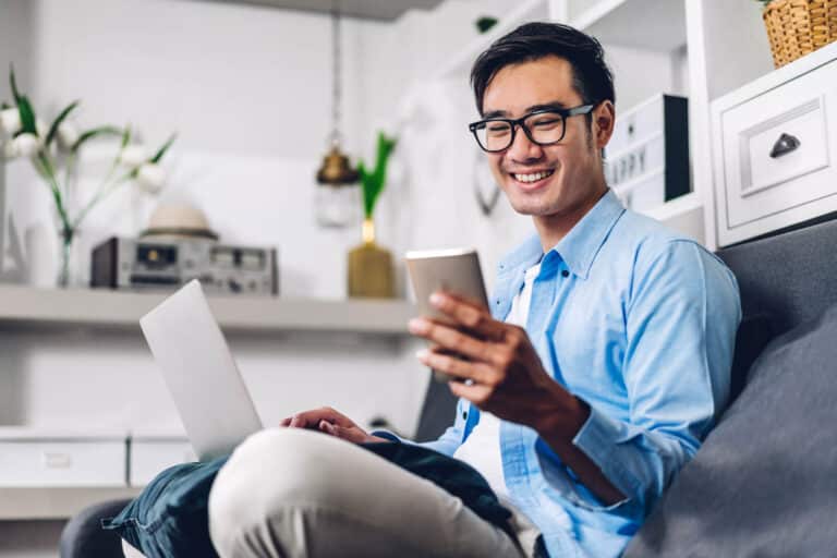 Man using phone and laptop connecting