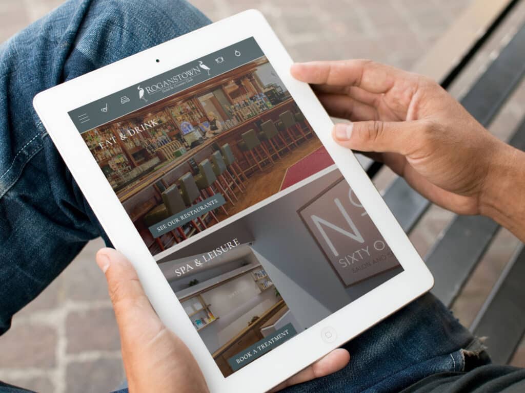 Man on ipad looking at roganstown website
